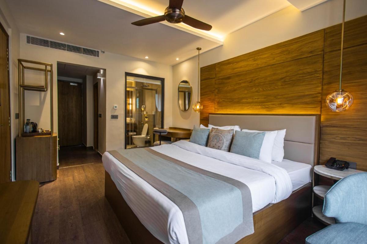 a hotel room with a large bed and a bathroom at Antalya By Divine Ganga Cottage in Rishīkesh
