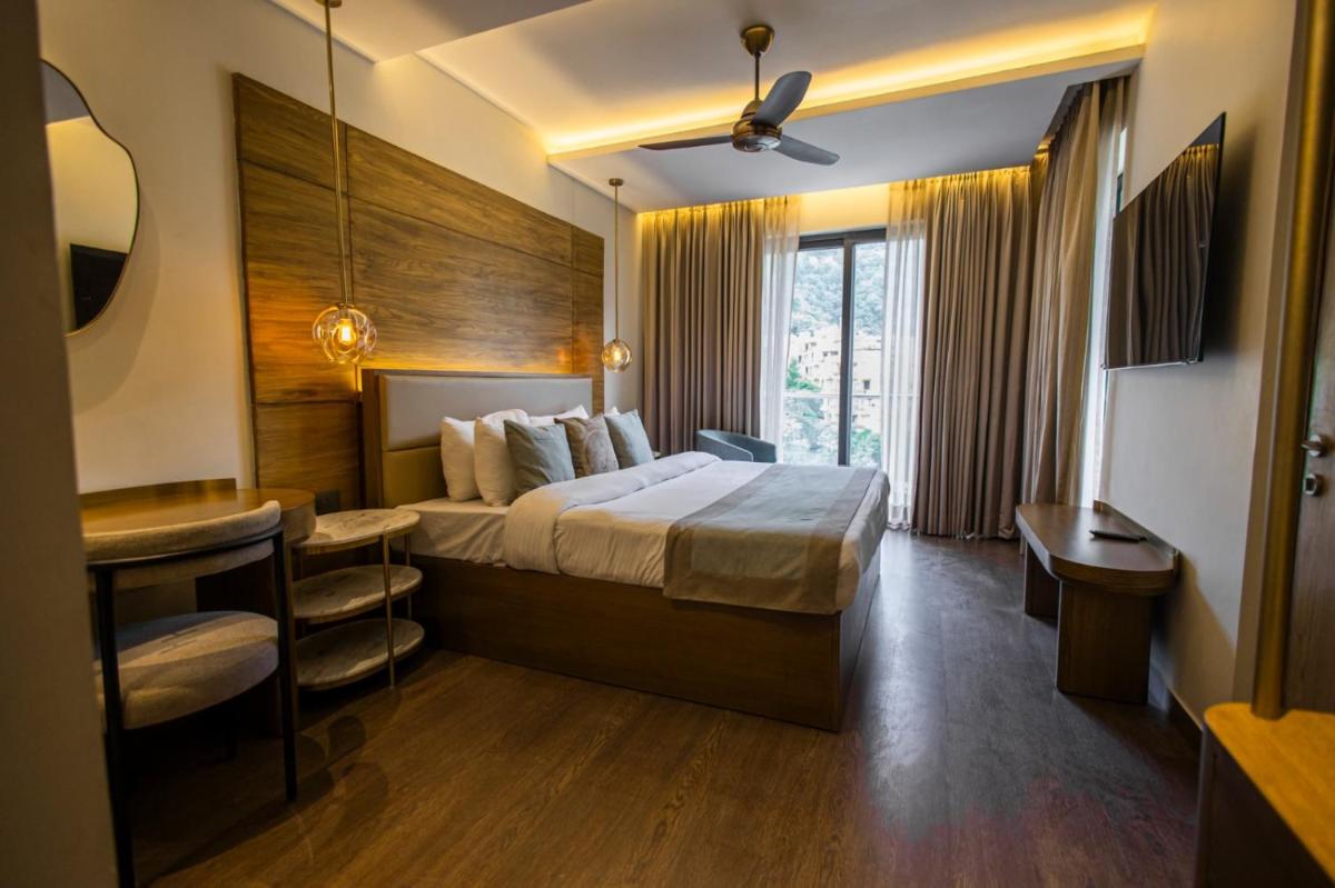 a hotel room with a bed and a desk at Antalya By Divine Ganga Cottage in Rishīkesh