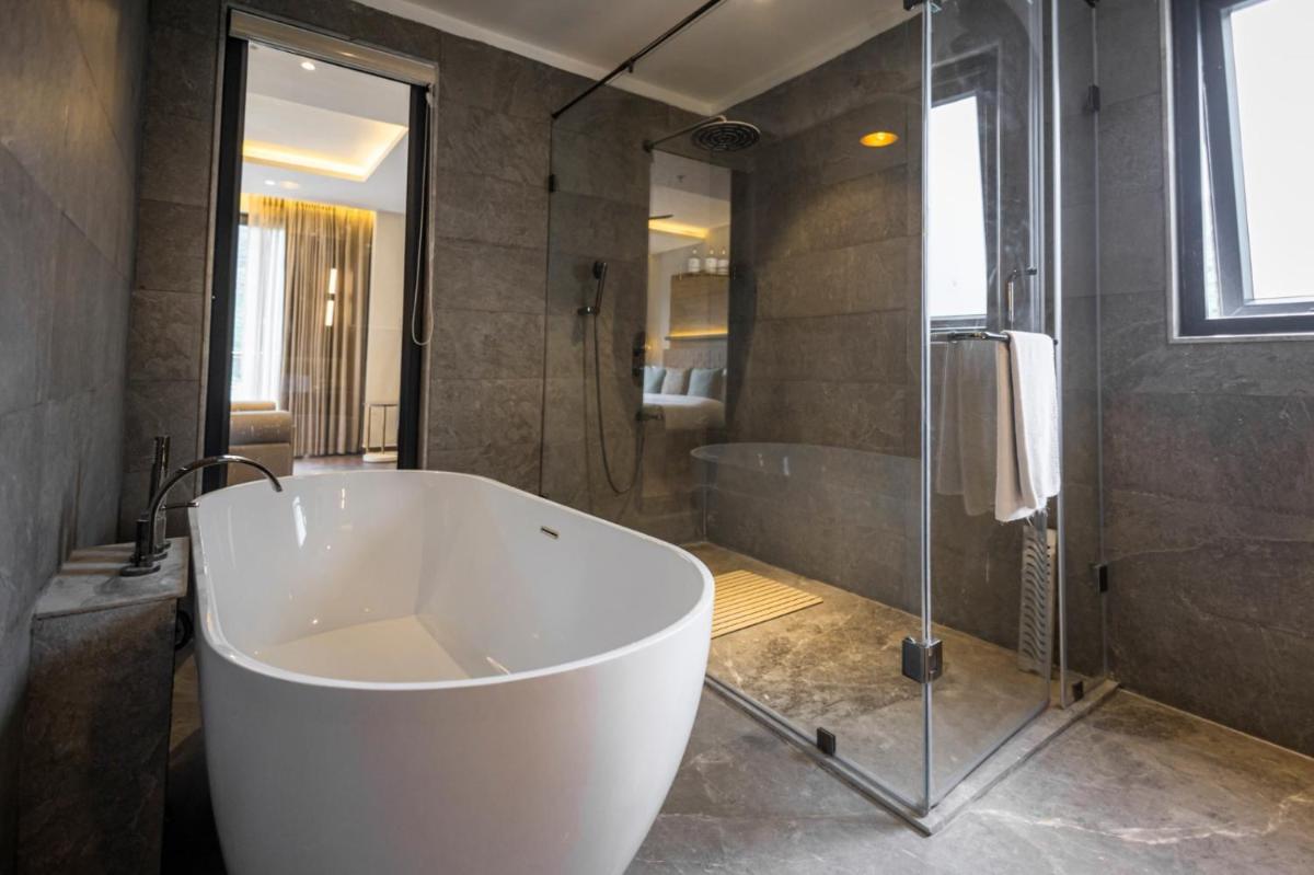 a large white tub in a bathroom with a shower at Antalya By Divine Ganga Cottage in Rishīkesh