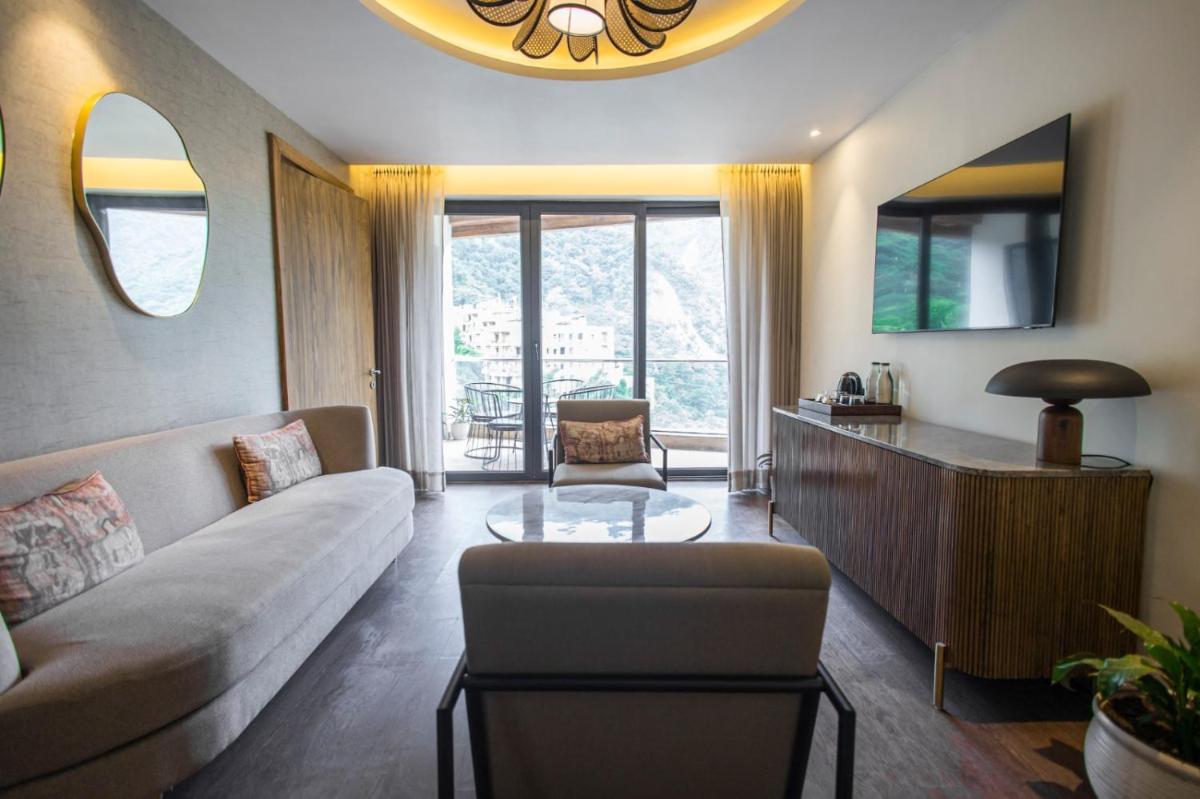 a living room with a couch and a table at Antalya By Divine Ganga Cottage in Rishīkesh