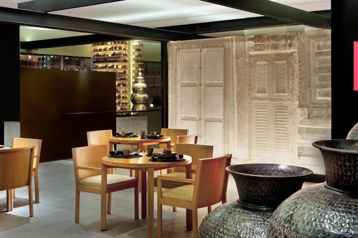 a dining room with a table and chairs and vases at The Westin Gurgaon, New Delhi in Gurgaon