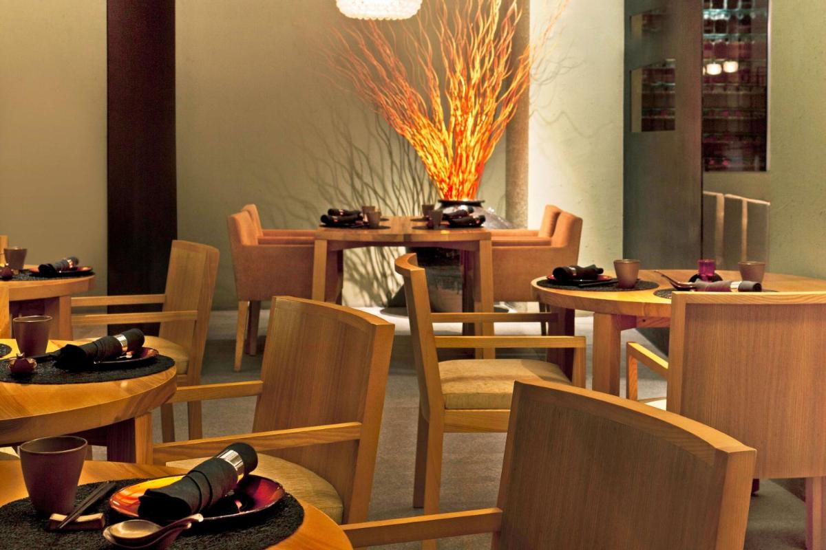 a restaurant with wooden tables and chairs and a dining room at The Westin Gurgaon, New Delhi in Gurgaon