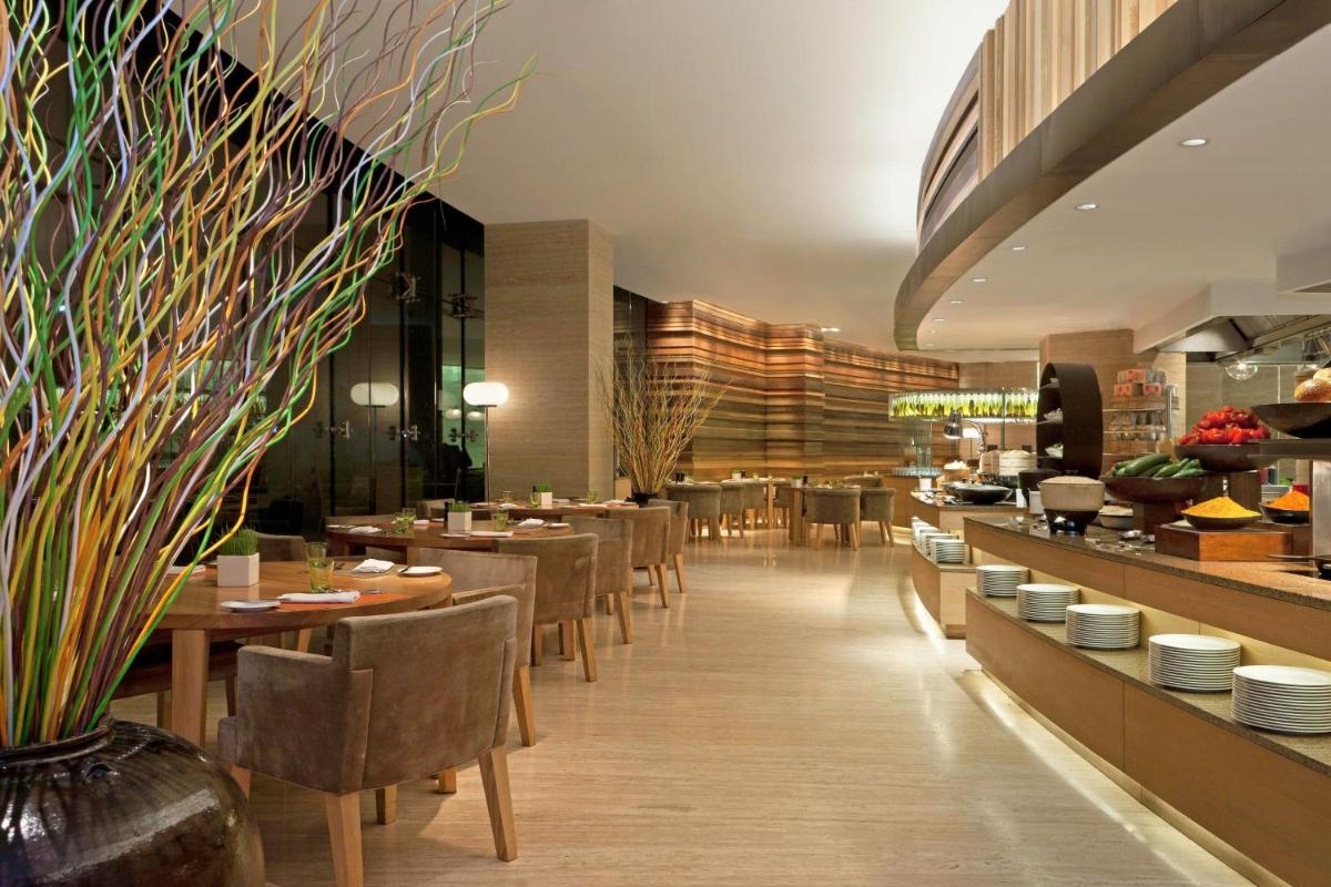 a restaurant with tables and chairs and a buffet at The Westin Gurgaon, New Delhi in Gurgaon