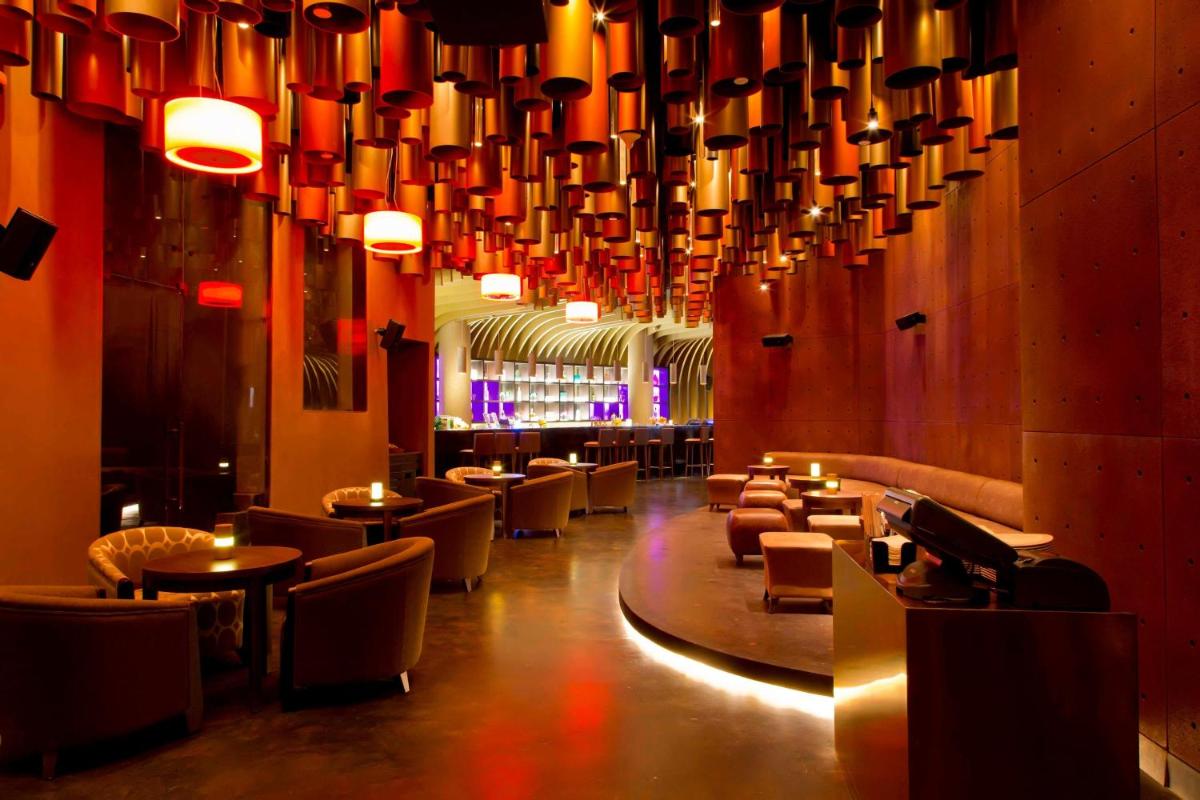 a restaurant with chairs and tables and a large chandelier at The Westin Gurgaon, New Delhi in Gurgaon
