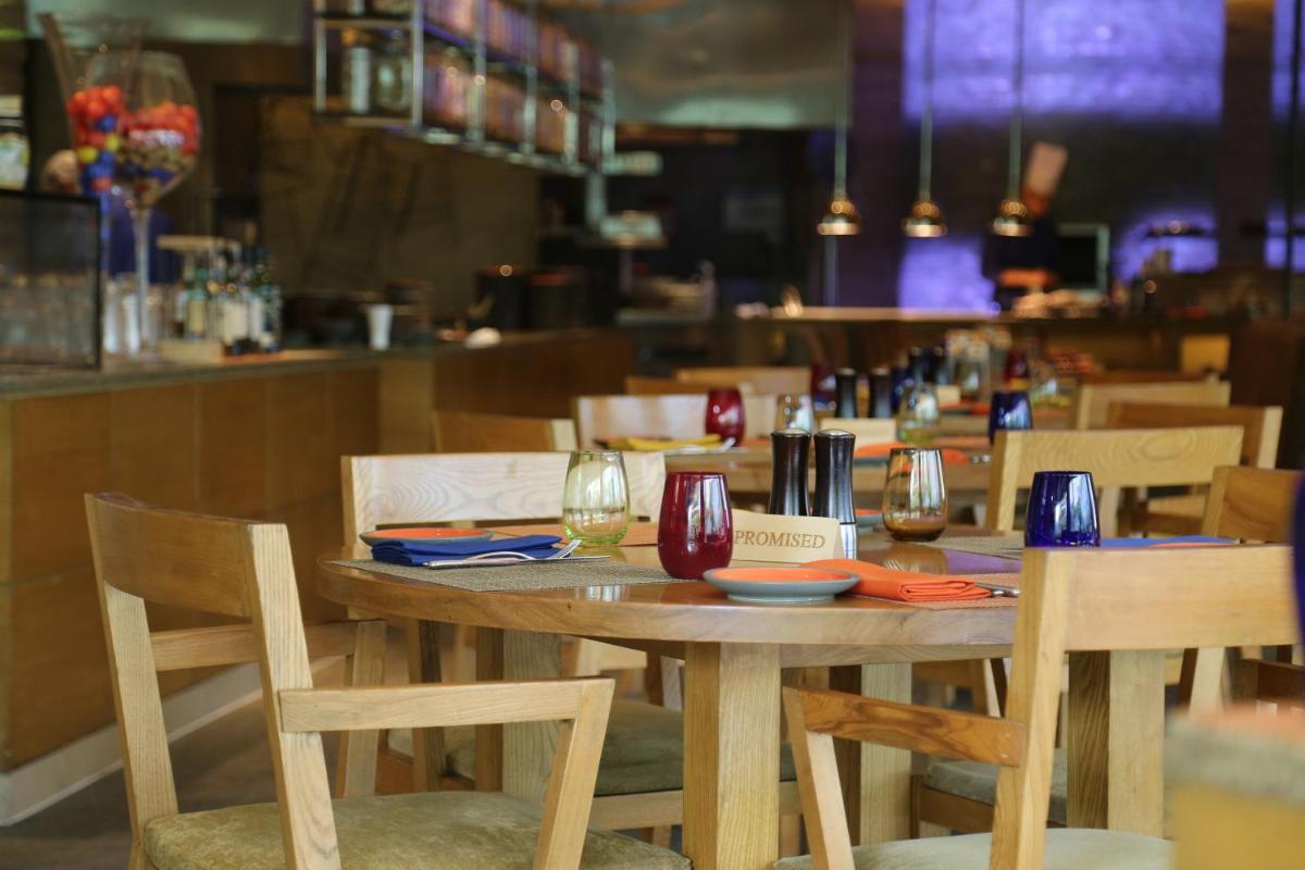 a wooden table in a restaurant with chairs and wine glasses at The Westin Gurgaon, New Delhi in Gurgaon