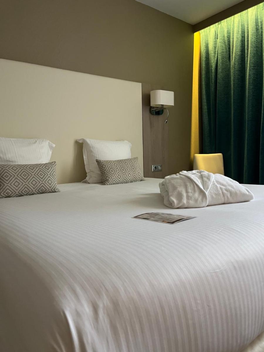 Un ou plusieurs lits dans un hébergement de l'établissement Hotel Normandy
