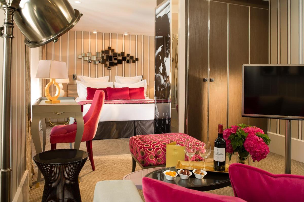 Cette chambre comprend un lit avec des oreillers rouges. dans l'établissement Hôtel Baume, à Paris