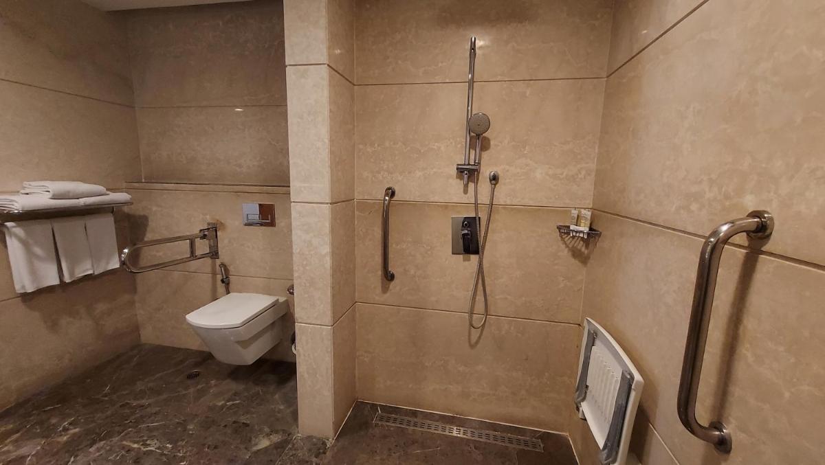a bathroom with a toilet and a shower with a phone at InterContinental Jaipur Tonk Road by IHG in Jaipur