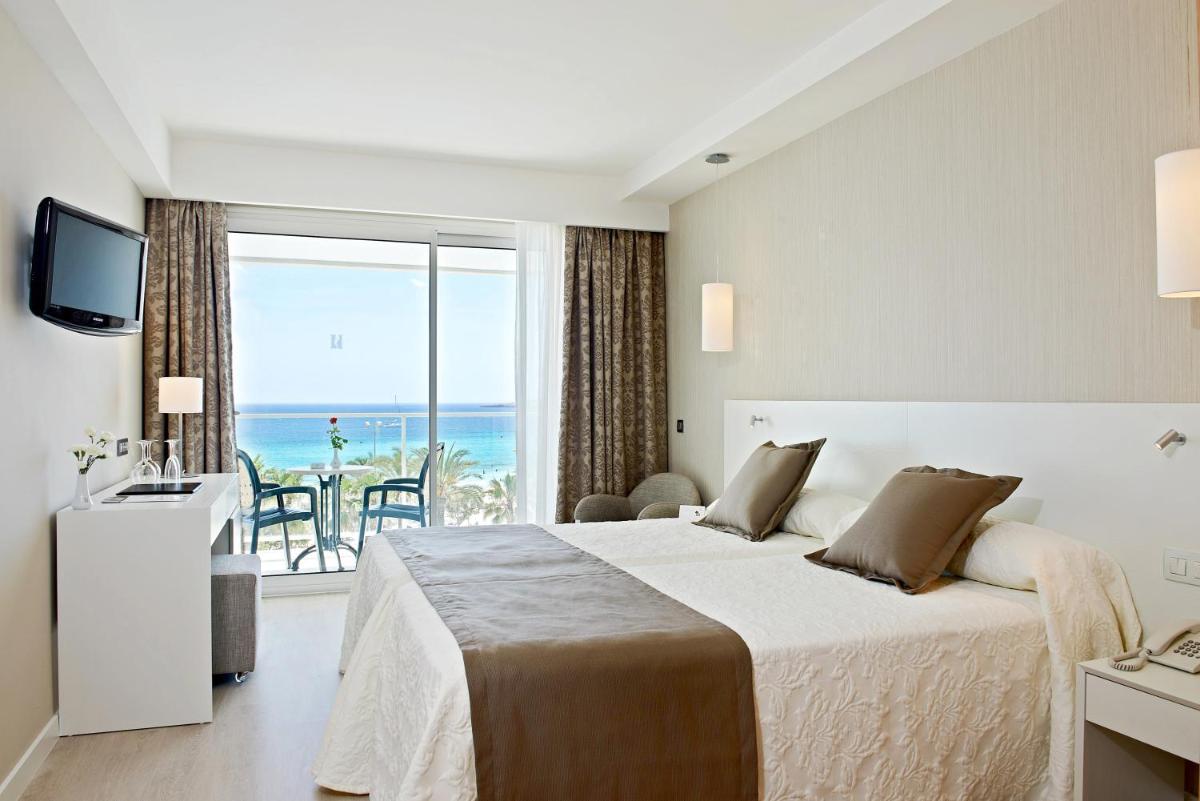 Un dormitorio con una cama con vista al mar. en Hipotels Hipocampo - Adults Only, en Cala Millor 25 fotos más