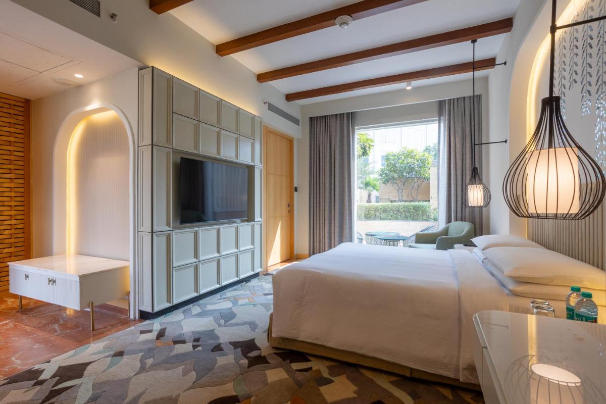 a bedroom with a large bed and a television at InterContinental Jaipur Tonk Road by IHG in Jaipur