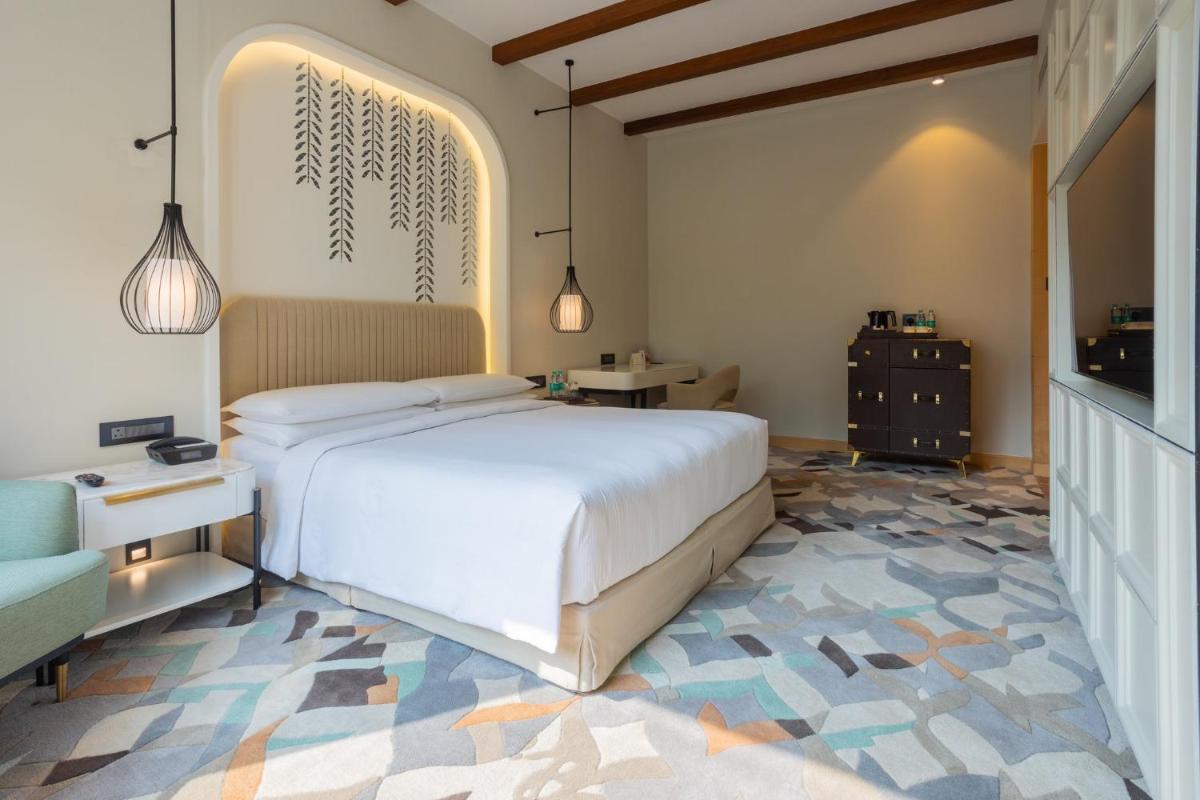a bedroom with a large white bed and a chair at InterContinental Jaipur Tonk Road by IHG in Jaipur