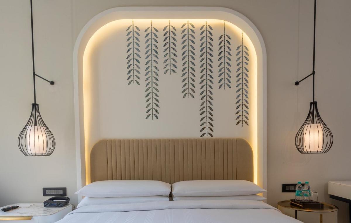 a bedroom with a bed with two lights above it at InterContinental Jaipur Tonk Road by IHG in Jaipur