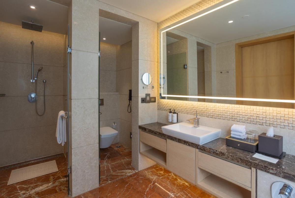 a bathroom with a sink and a shower and a mirror at InterContinental Jaipur Tonk Road by IHG in Jaipur