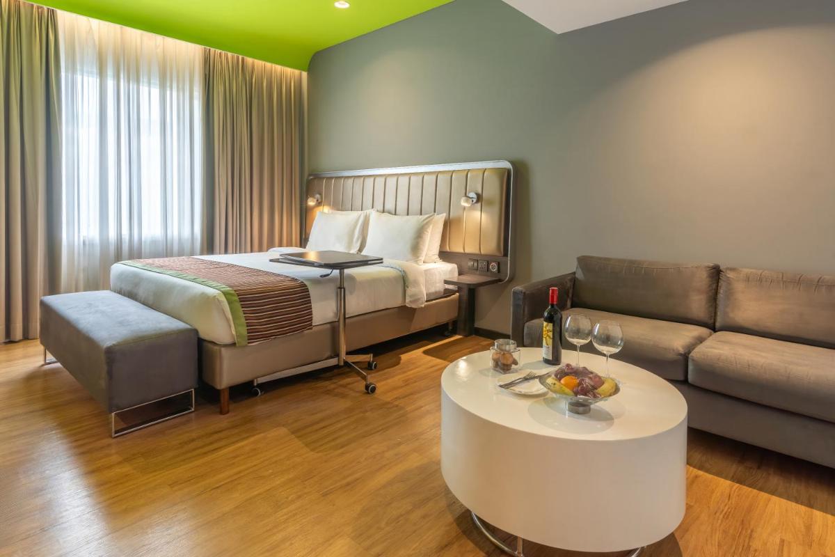 a hotel room with a bed and a couch at Park Inn by Radisson,South Delhi in New Delhi a hotel room with a bed and a couch at Park Inn by Radisson,South Delhi in New Delhi