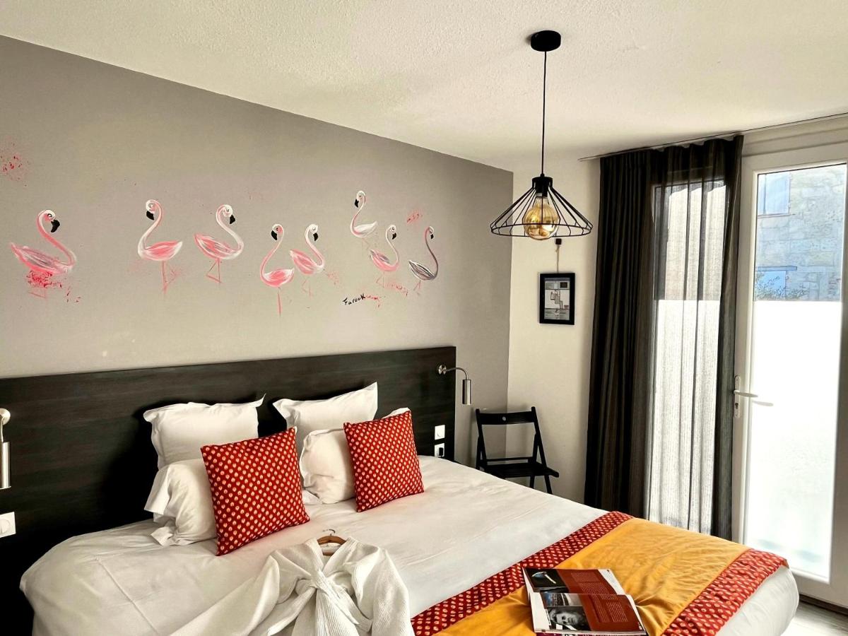 - une chambre avec un lit avec des flamants roses sur le mur dans l'établissement Hôtel Saint Louis, à Aigues-Mortes 82 autres photos