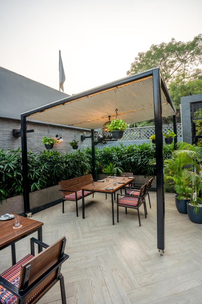a patio with tables and chairs under a canopy at Park Inn by Radisson,South Delhi in New Delhi a patio with tables and chairs under a canopy at Park Inn by Radisson,South Delhi in New Delhi