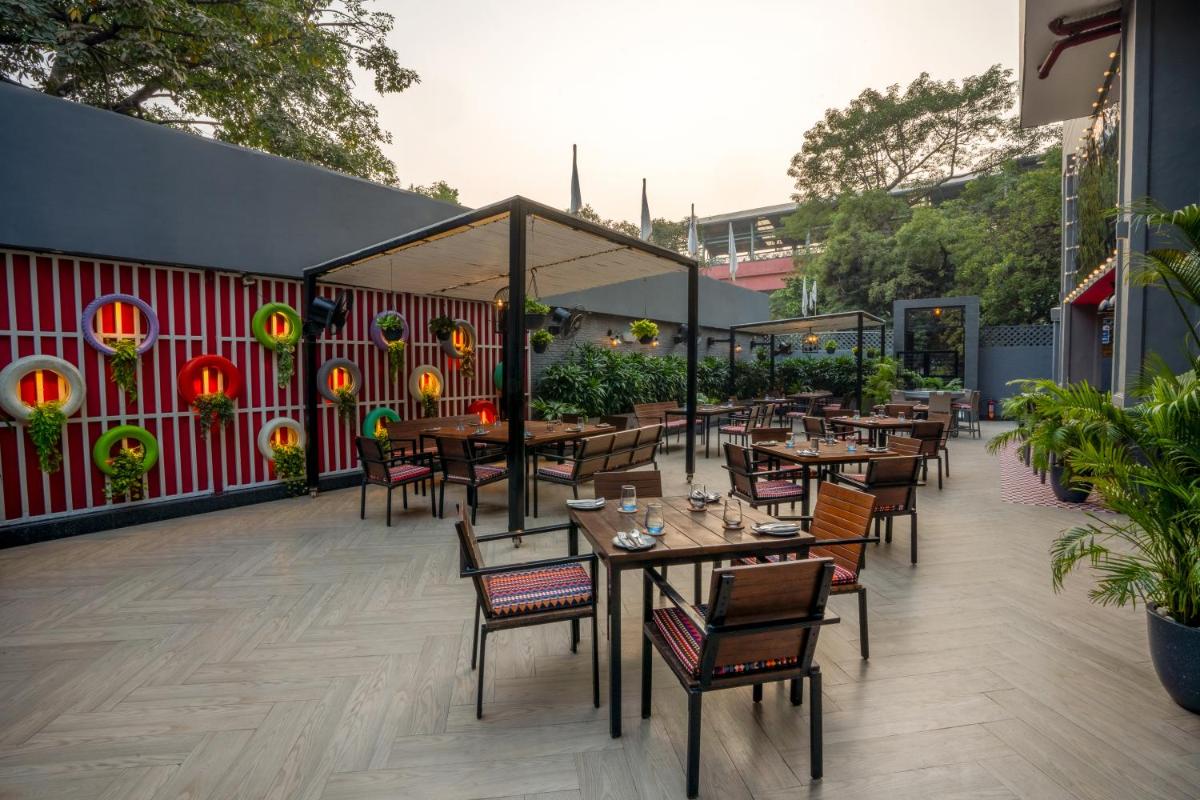 a restaurant with tables and chairs on a patio at Park Inn by Radisson,South Delhi in New Delhi a restaurant with tables and chairs on a patio at Park Inn by Radisson,South Delhi in New Delhi