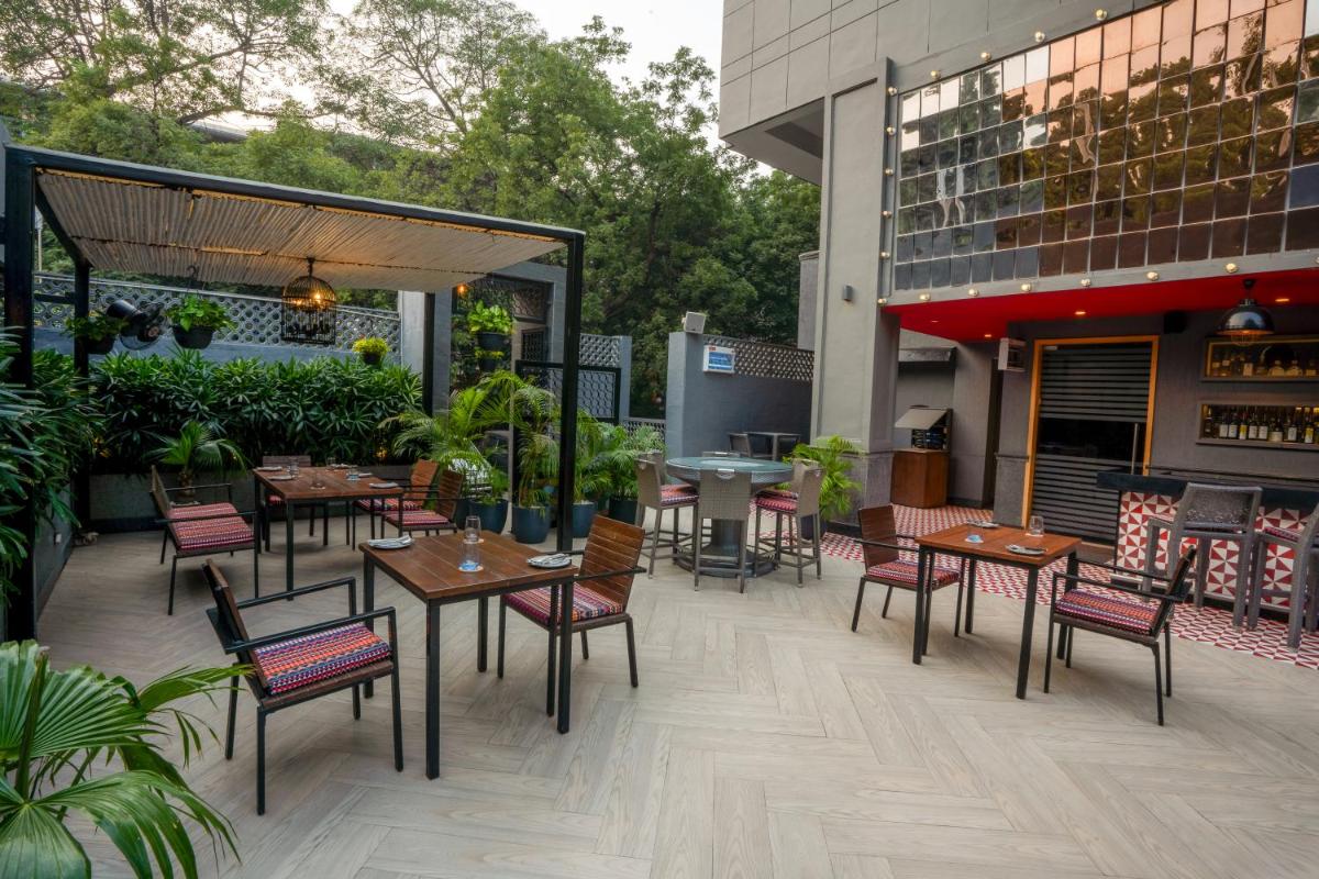 a patio with tables and chairs on a building at Park Inn by Radisson,South Delhi in New Delhi a patio with tables and chairs on a building at Park Inn by Radisson,South Delhi in New Delhi