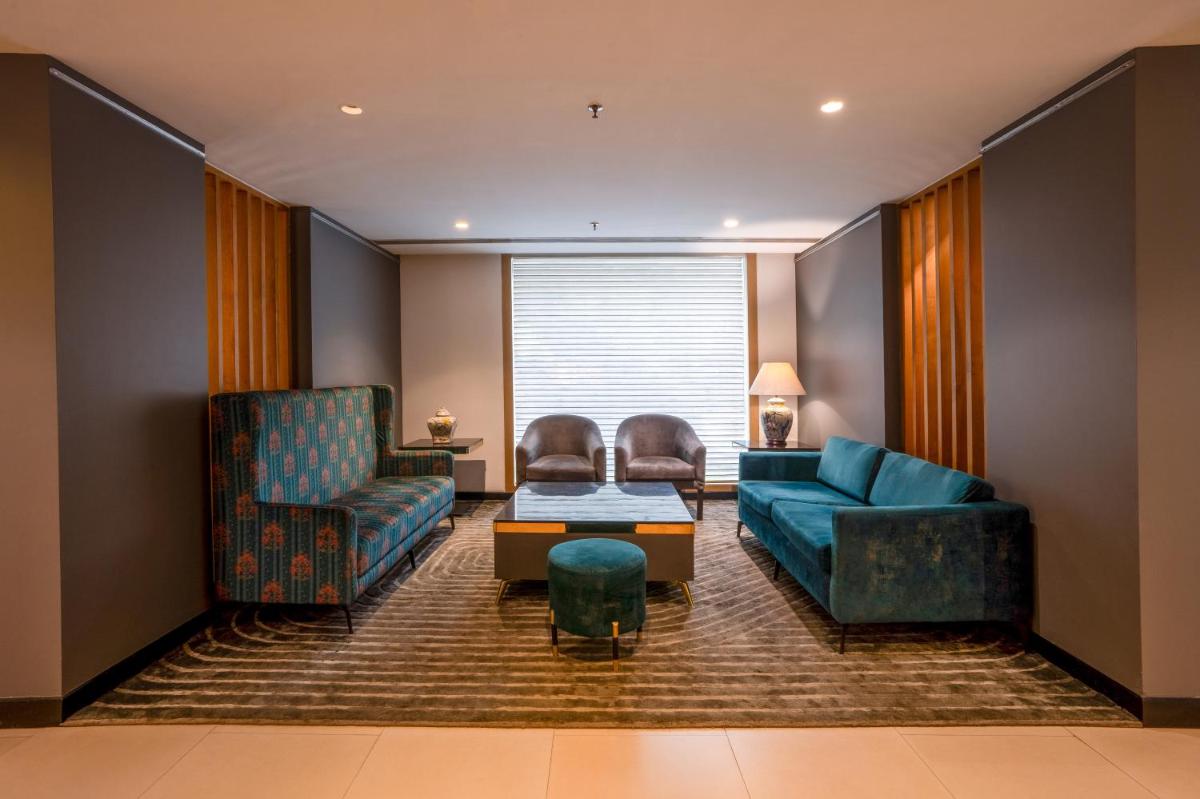 a living room with a couch and chairs and a table at Park Inn by Radisson,South Delhi in New Delhi +102 photos a living room with a couch and chairs and a table at Park Inn by Radisson,South Delhi in New Delhi +102 photos