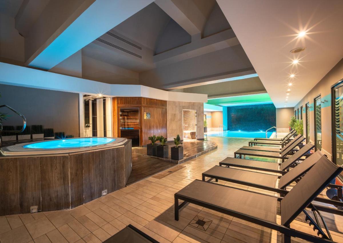 un hall avec une piscine pour la nage en longueur et un spa dans l'établissement Hotel Spa Le Pasino, au Havre