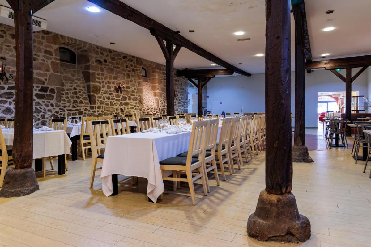 une salle à manger avec une table et des chaises blanches dans l'établissement Logis Hôtel Restaurant Auberge de la Xaintrie, à Saint-Privat