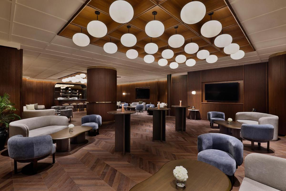 a waiting room with tables and chairs and a tv at Shangri-La Eros New Delhi in New Delhi a waiting room with tables and chairs and a tv at Shangri-La Eros New Delhi in New Delhi