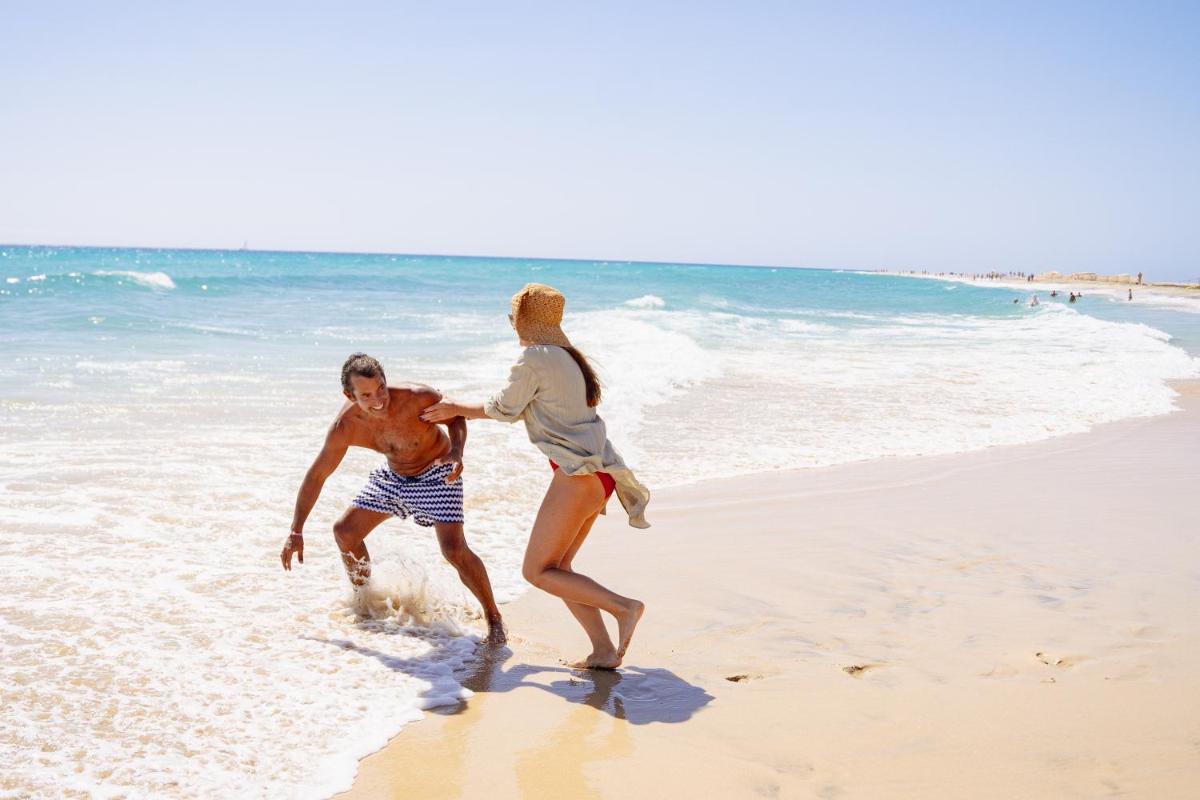un hombre y una mujer jugando en la playa en Iberostar Waves Gaviotas Park, en Morro del Jable