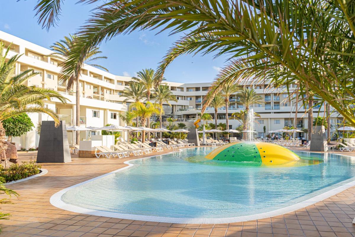 Una piscina en un resort con un tobogán en el medio. en Iberostar Waves Gaviotas Park, en Morro del Jable