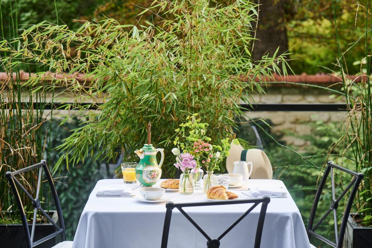 - une table blanche avec des croissants et un vase dans l'établissement Maison Boissière BARNES Residences, à Paris