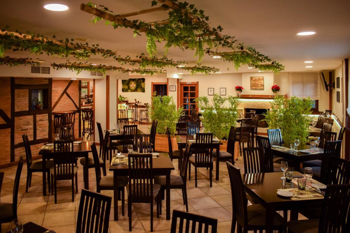 Un restaurante con mesas y sillas en una habitación. en Hotel Spa San Marcos, en Santillana del Mar