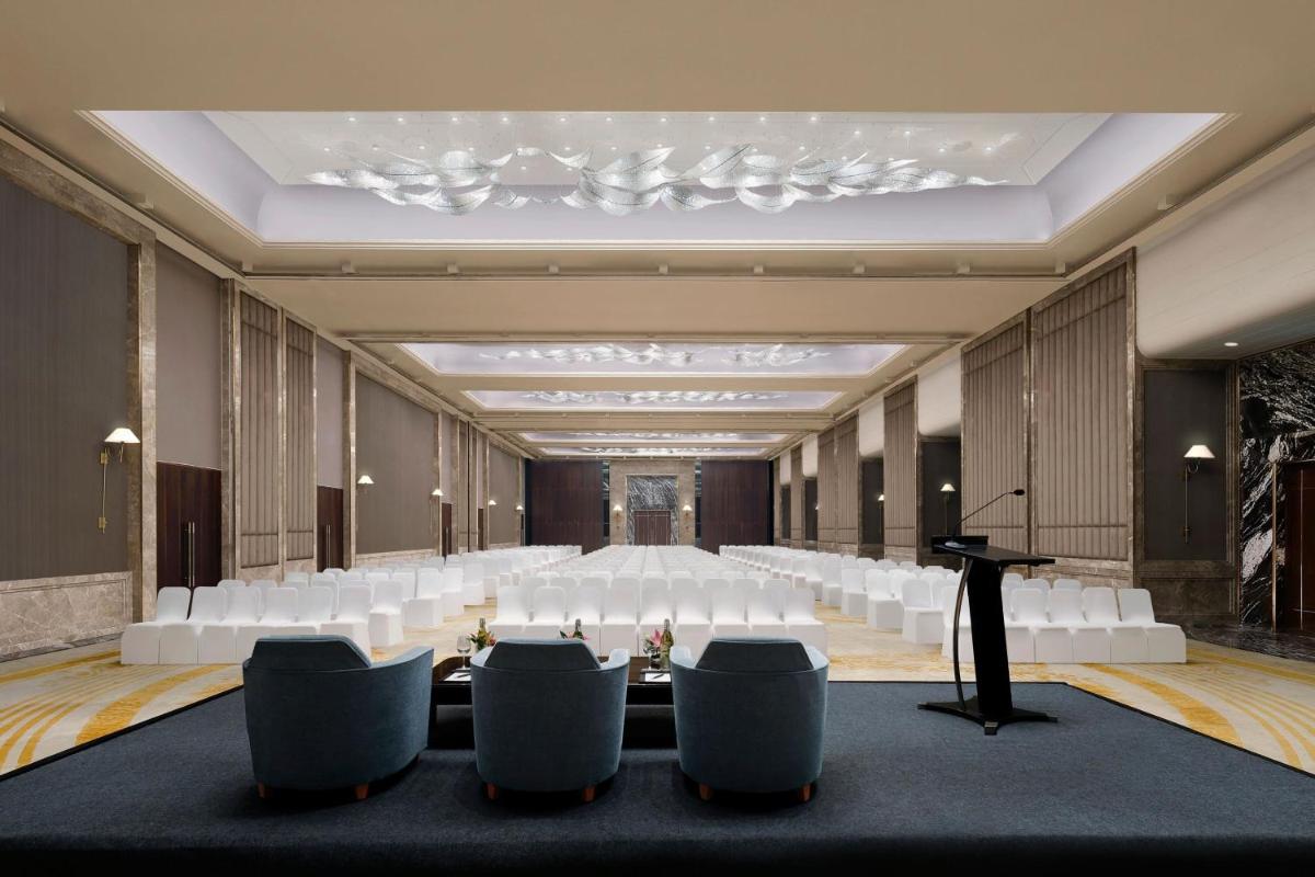 a conference room with white chairs and a podium at The Westin Pune Koregaon Park in Pune
