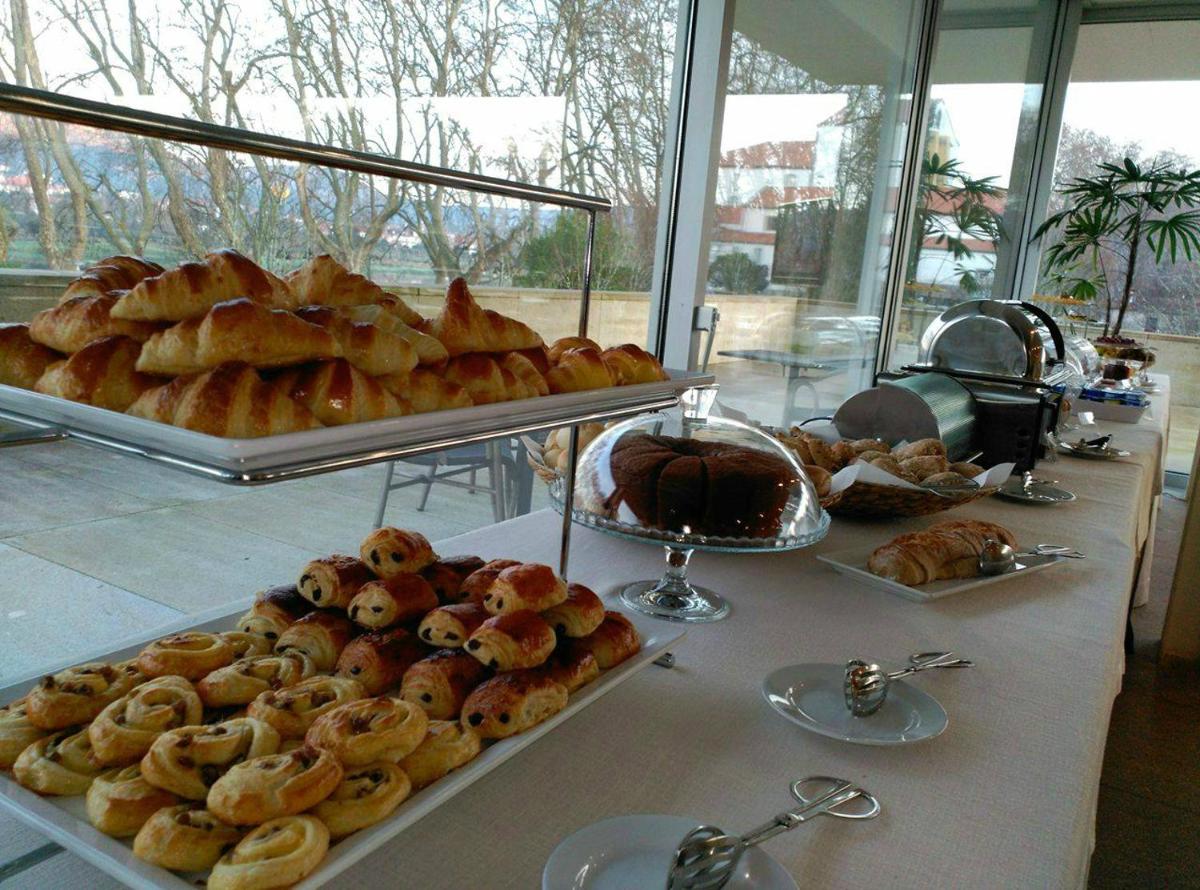 um buffet de produtos de pastelaria e pães numa mesa em INLIMA Hotel & Spa em Ponte de Lima