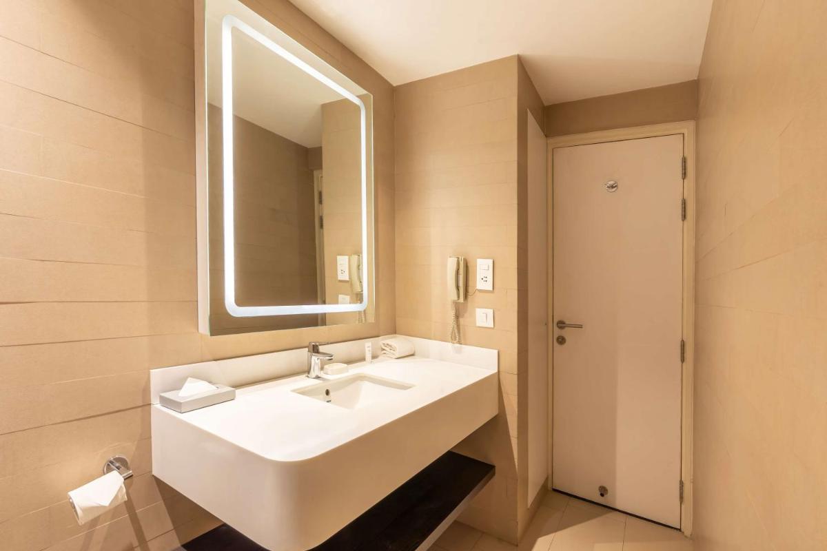 a bathroom with a white sink and a mirror at Park Inn by Radisson,South Delhi in New Delhi a bathroom with a white sink and a mirror at Park Inn by Radisson,South Delhi in New Delhi