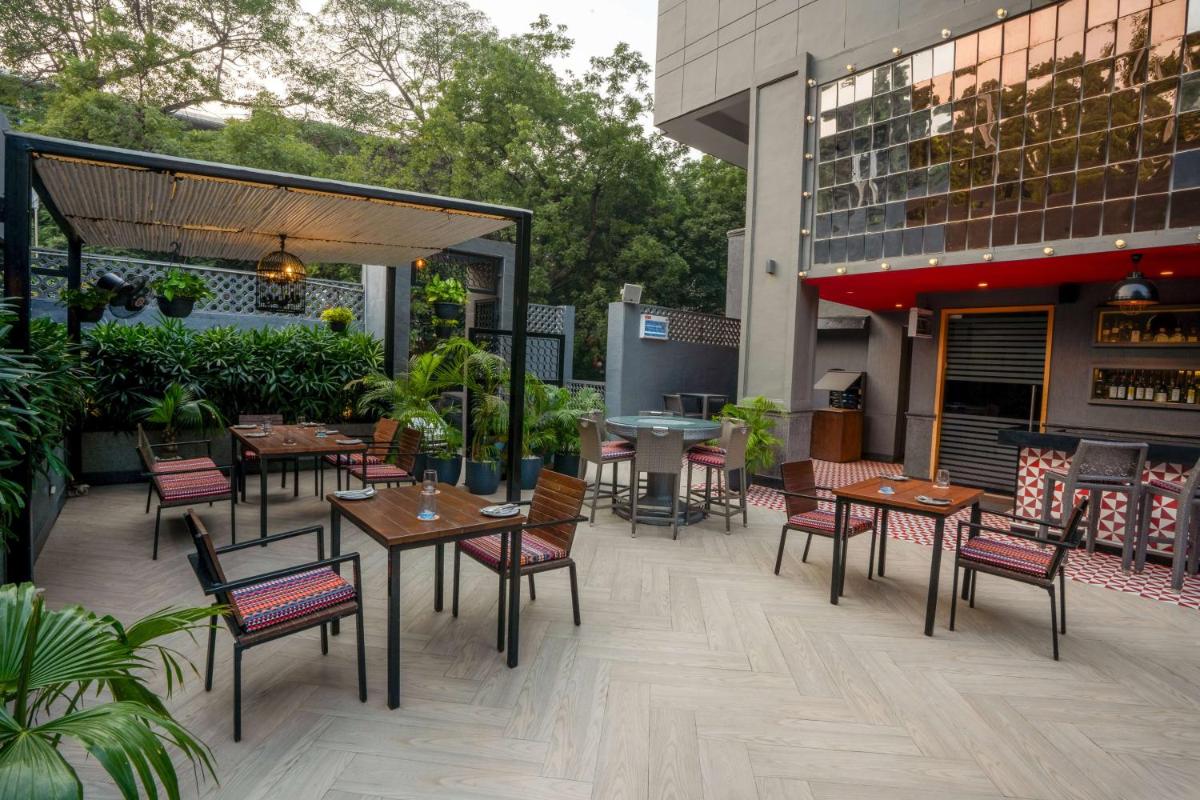 a patio with tables and chairs on a building at Park Inn by Radisson,South Delhi in New Delhi a patio with tables and chairs on a building at Park Inn by Radisson,South Delhi in New Delhi