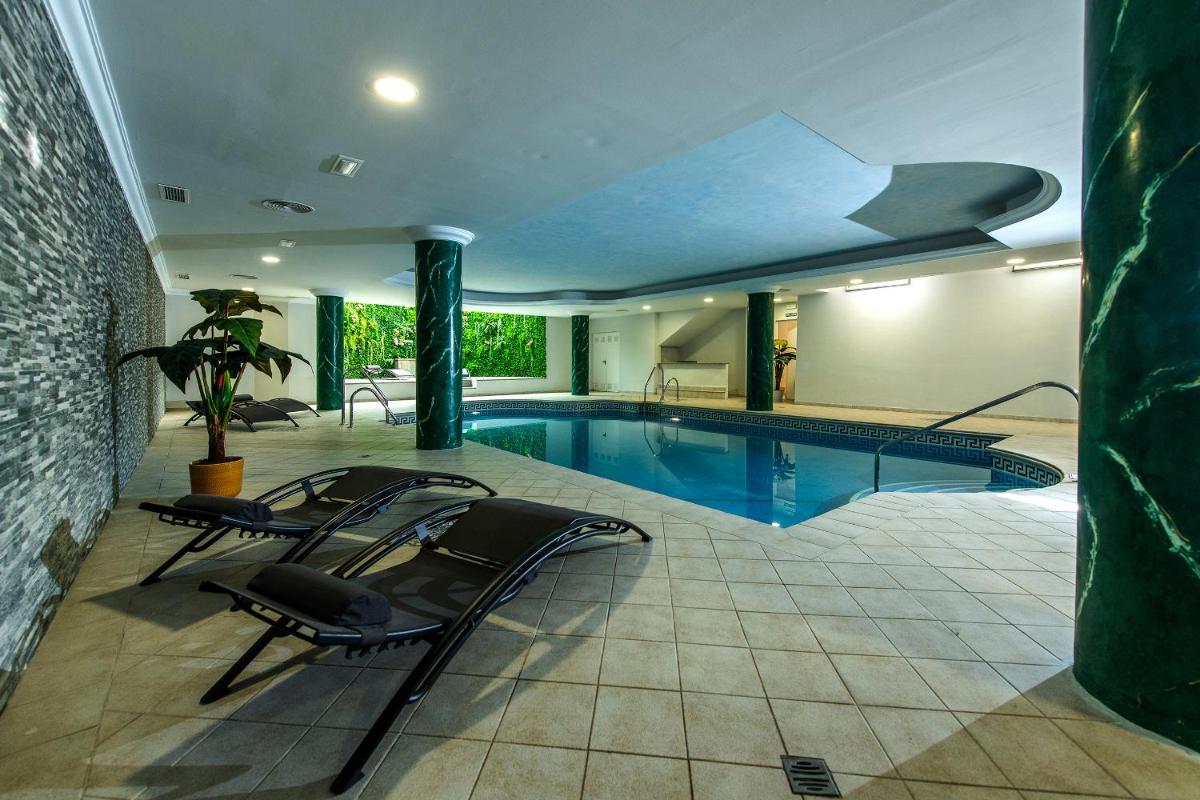 una piscina en una casa con sillas alrededor en Hotel Tamisa Golf, en Mijas