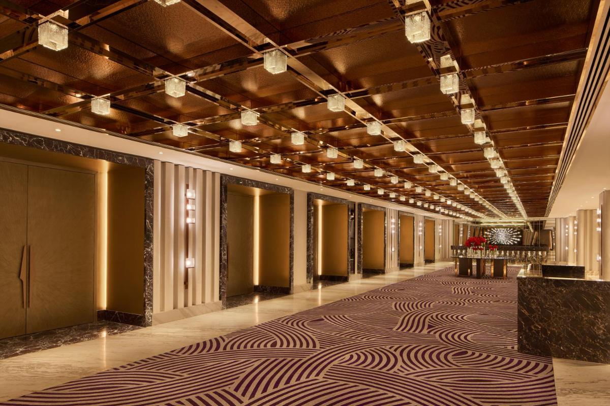 a hallway of a hotel with a carpet on the floor at Grand Hyatt Mumbai Hotel and Residences in Mumbai