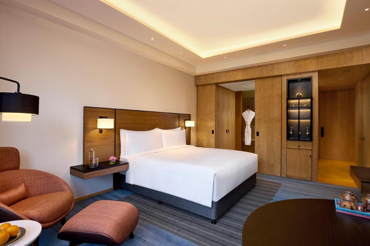 a hotel room with a bed and a chair at Grand Hyatt Mumbai Hotel and Residences in Mumbai
