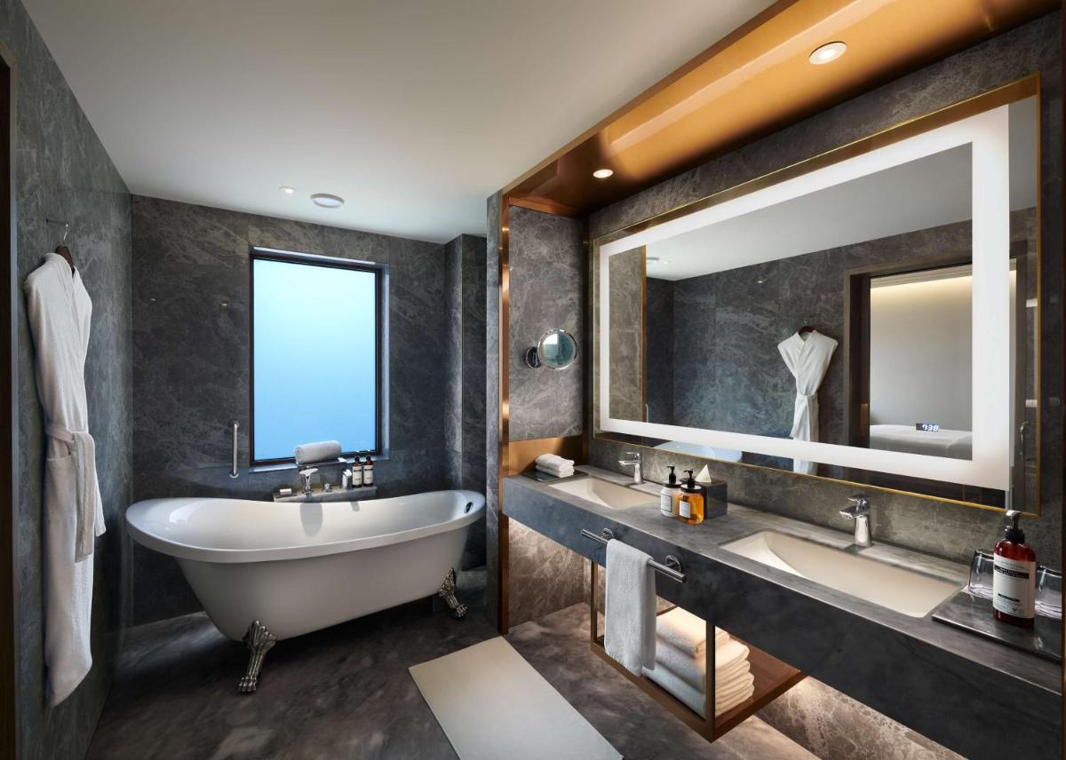 a bathroom with two sinks and a tub and a large mirror at Hyatt Regency Jaipur Mansarovar in Jaipur a bathroom with two sinks and a tub and a large mirror at Hyatt Regency Jaipur Mansarovar in Jaipur