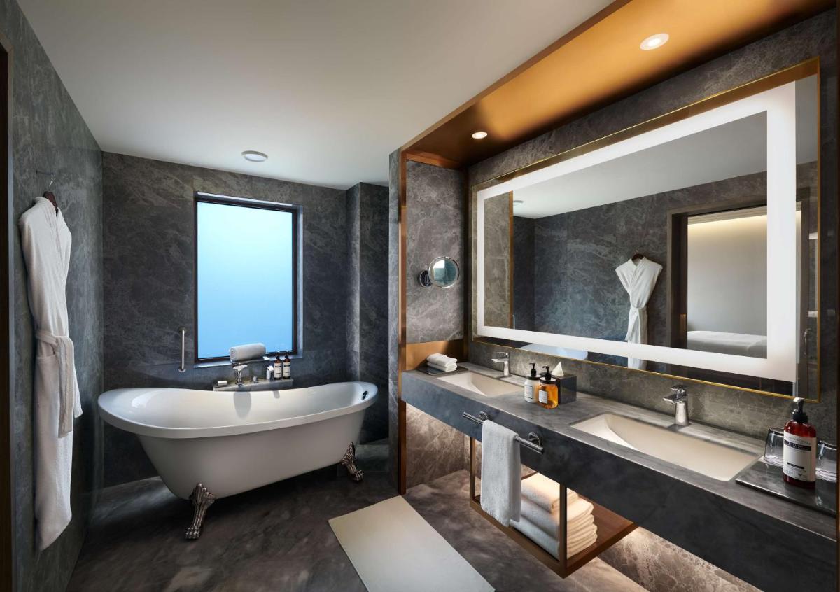 a bathroom with two sinks and a tub and a large mirror at Hyatt Regency Jaipur Mansarovar in Jaipur a bathroom with two sinks and a tub and a large mirror at Hyatt Regency Jaipur Mansarovar in Jaipur