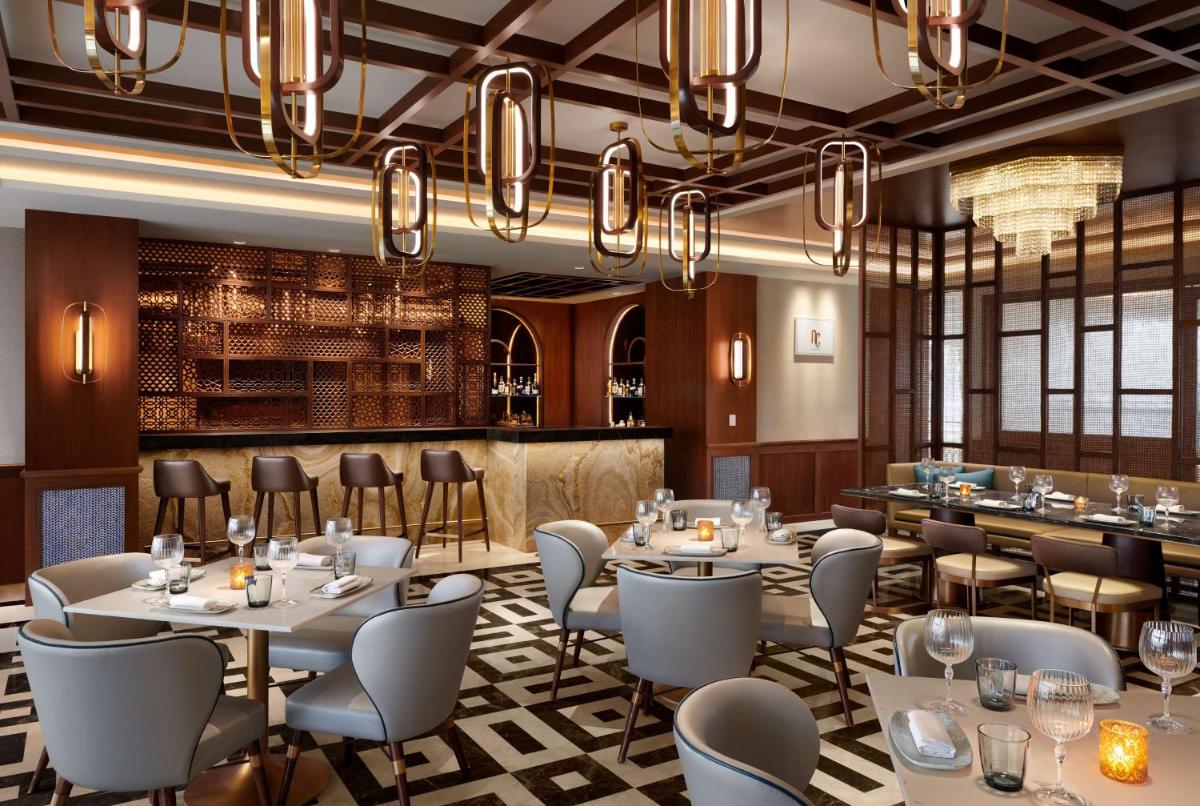 a restaurant with tables and chairs and a bar at Hyatt Regency Jaipur Mansarovar in Jaipur a restaurant with tables and chairs and a bar at Hyatt Regency Jaipur Mansarovar in Jaipur