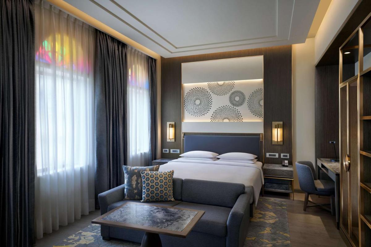 a hotel room with a bed and a couch at Hyatt Regency Jaipur Mansarovar in Jaipur a hotel room with a bed and a couch at Hyatt Regency Jaipur Mansarovar in Jaipur