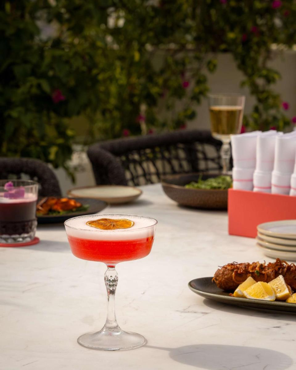 a drink in a glass on a table with food at Hyatt Regency Jaipur Mansarovar in Jaipur a drink in a glass on a table with food at Hyatt Regency Jaipur Mansarovar in Jaipur