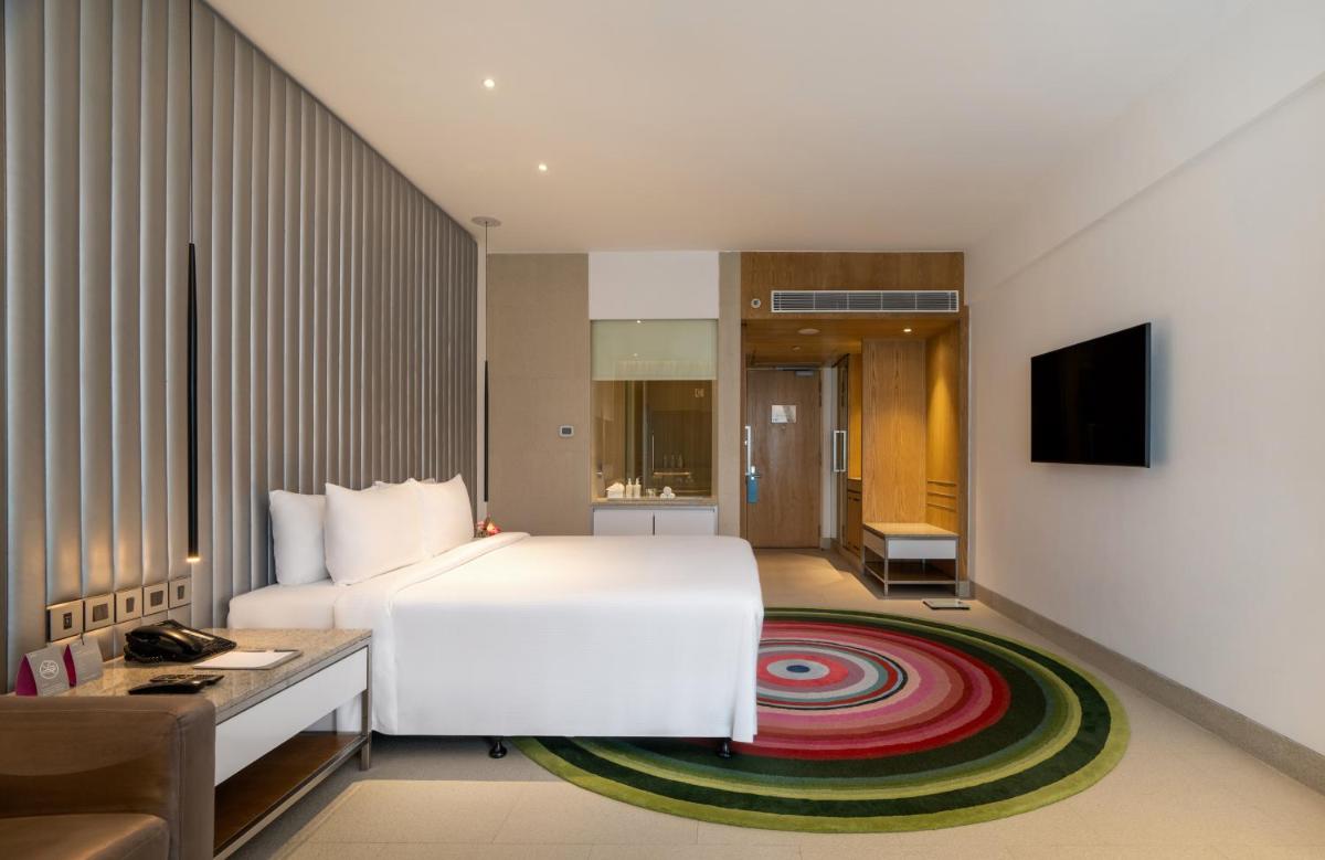 a hotel room with a white bed and a television at Avasa Hotel in Hyderabad