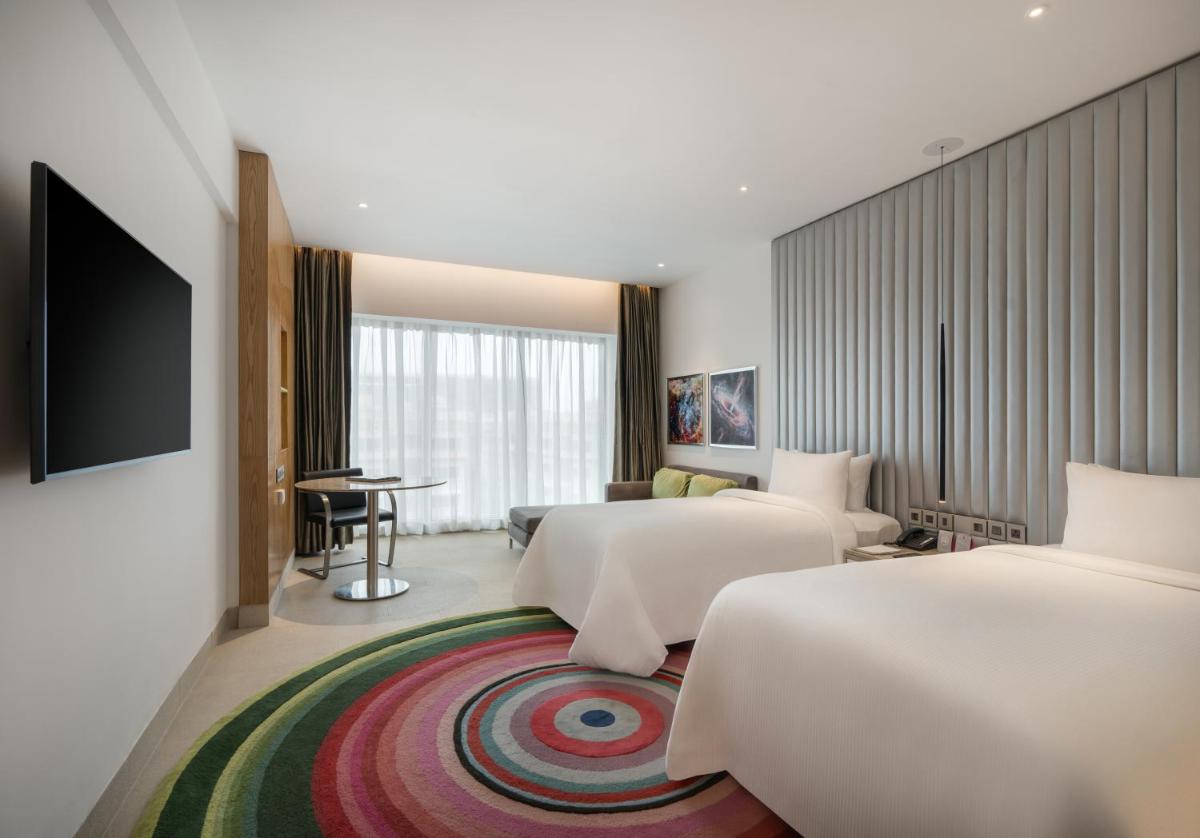 a hotel room with two beds and a flat screen tv at Avasa Hotel in Hyderabad