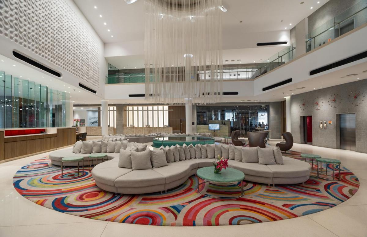 a lobby with a large couch and tables on a rug at Avasa Hotel in Hyderabad