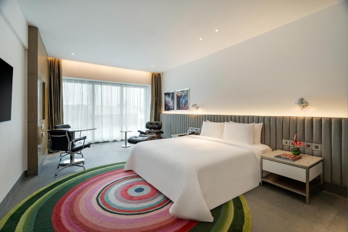 a hotel room with a large bed and a desk at Avasa Hotel in Hyderabad