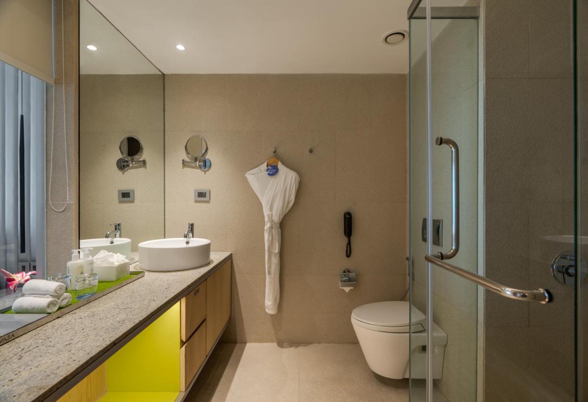 a bathroom with a toilet and a sink and a shower at Avasa Hotel in Hyderabad