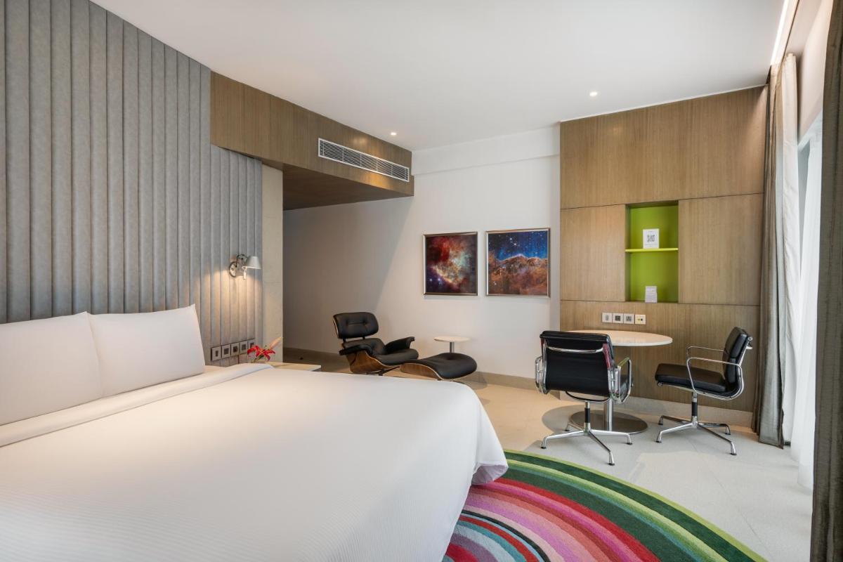 a bedroom with a bed and a table and chairs at Avasa Hotel in Hyderabad