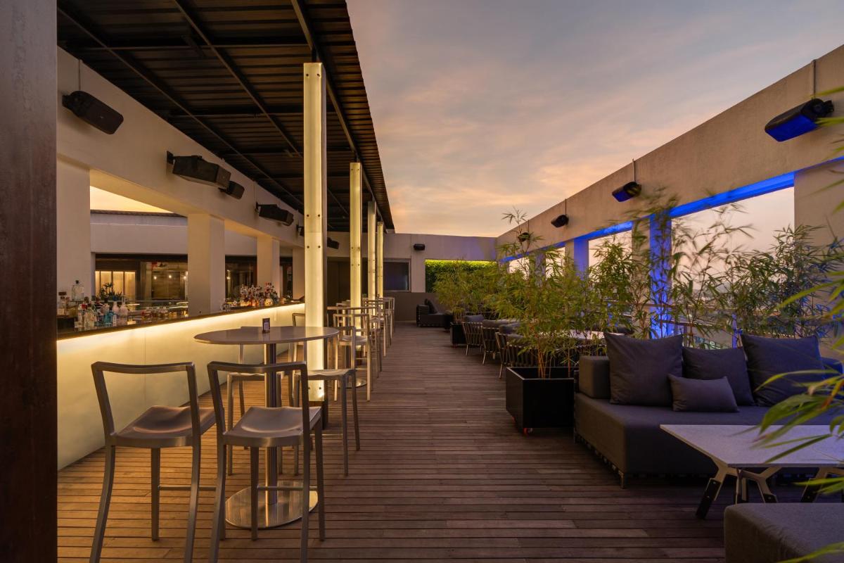 a restaurant with tables and chairs and a bar at Avasa Hotel in Hyderabad