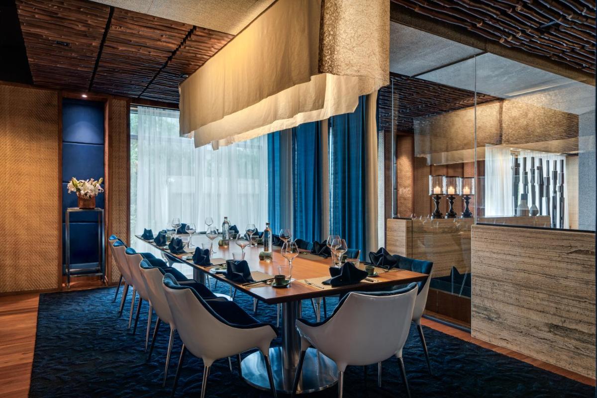 a long dining room with a long table and chairs at Avasa Hotel in Hyderabad